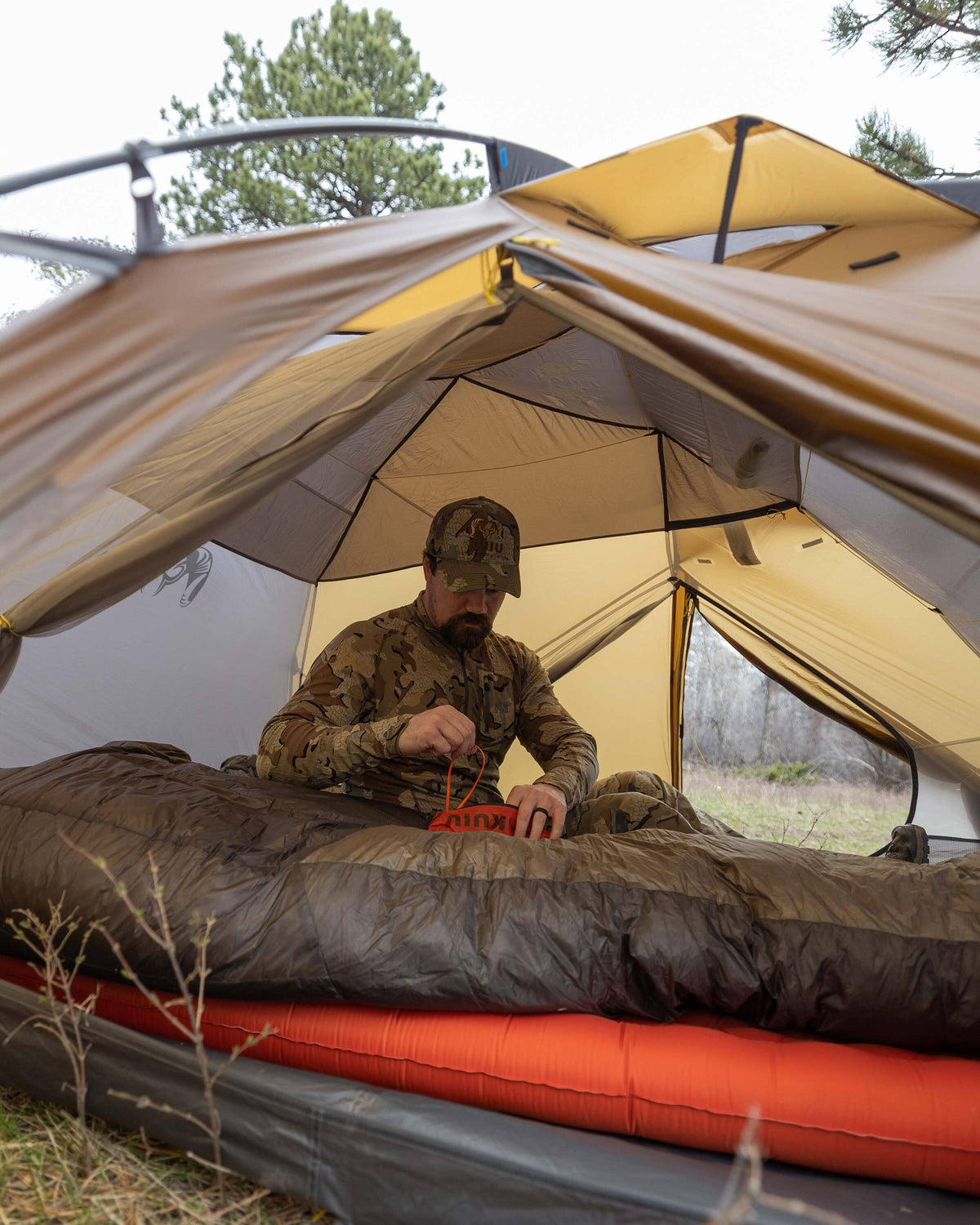 Hunter arranging a sleeping bag inside the Mountain Star 3P