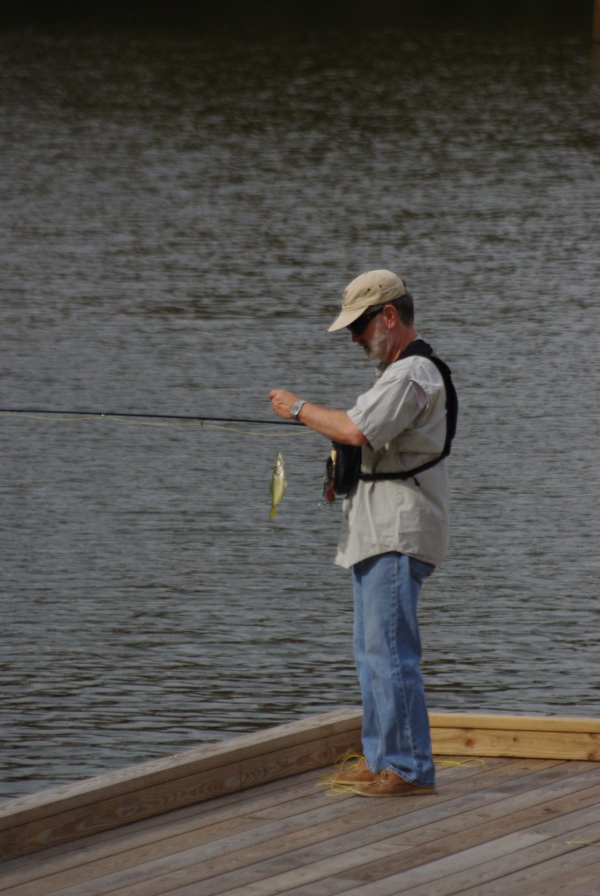 Fly angler landing a fish in shallow water