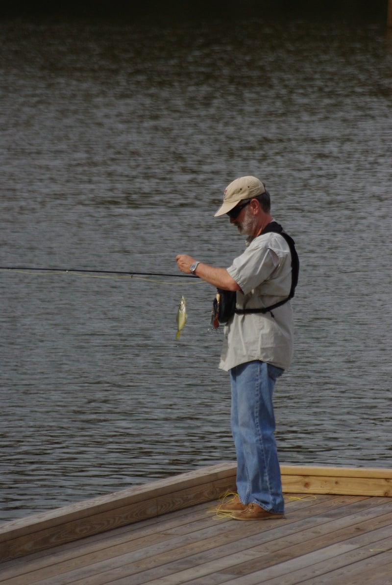Fly angler landing a fish in shallow water